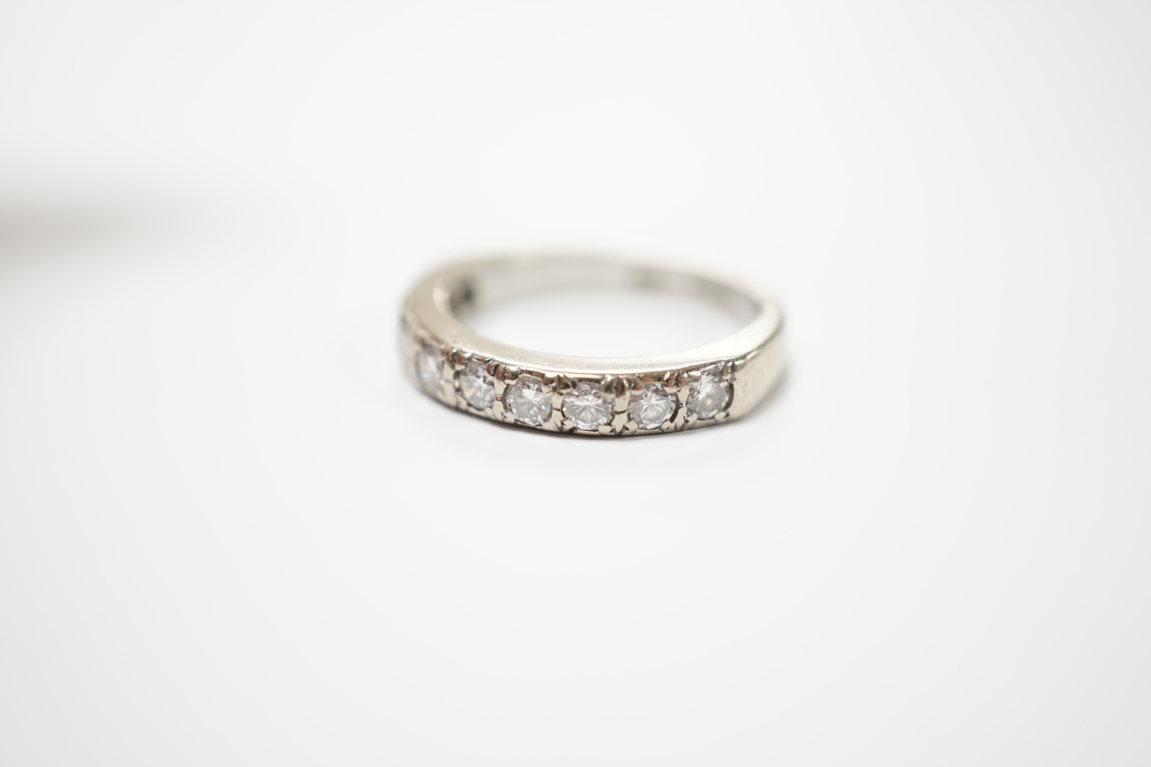 A modern 18ct white gold and nine stone diamond set half eternity ring, size M, gross weight 5.3 grams.
